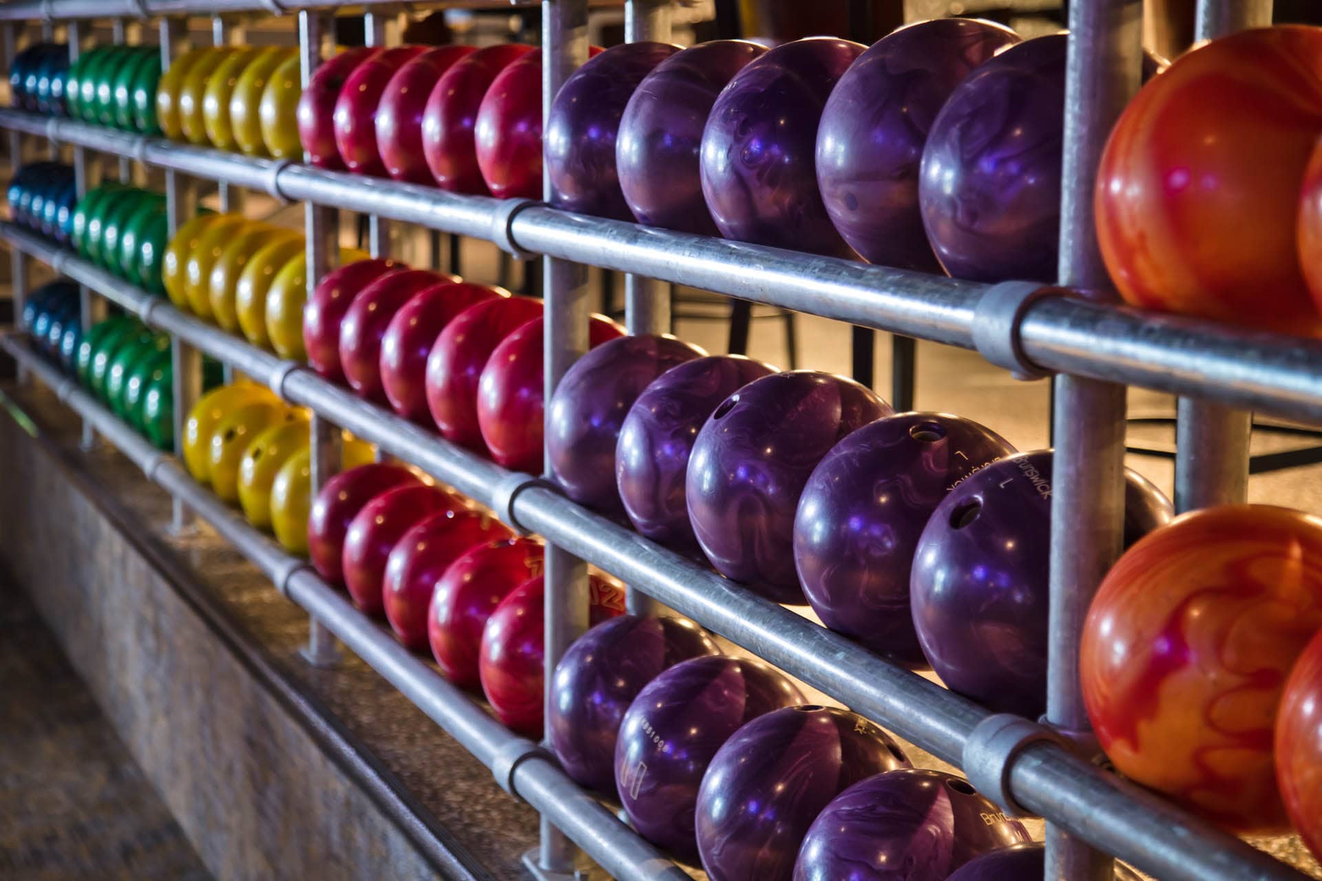 Racks of multicolored bowling balls.