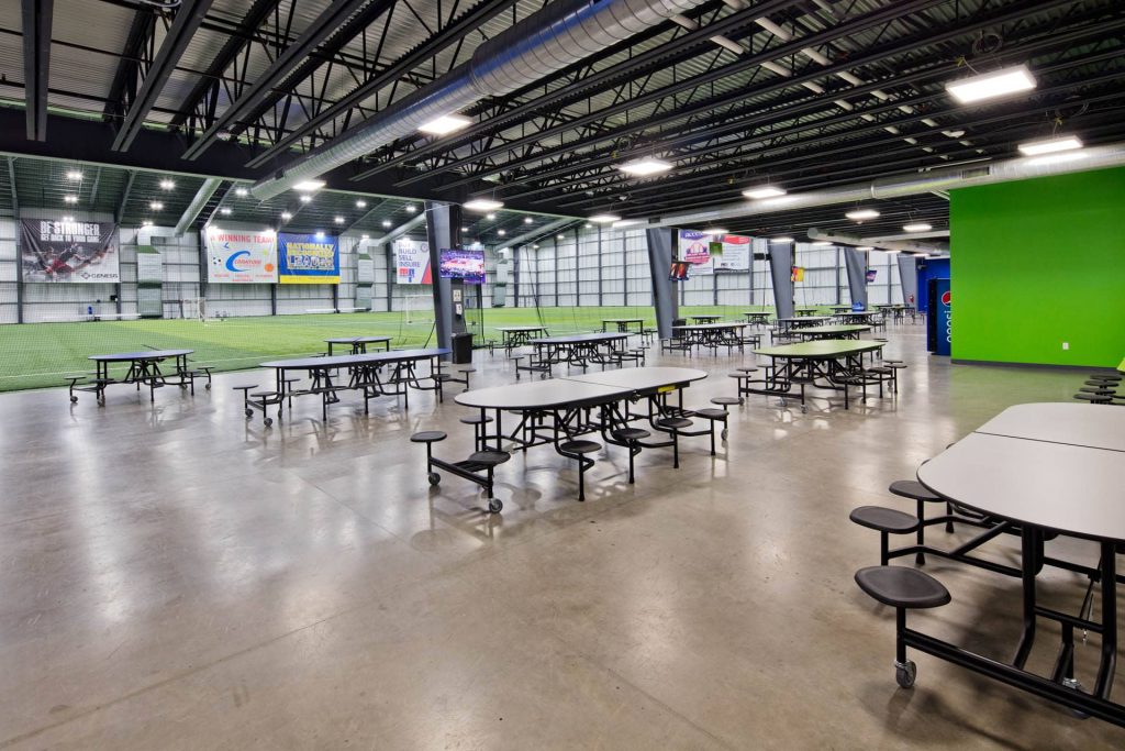 Indoor sports complex with tables up front.