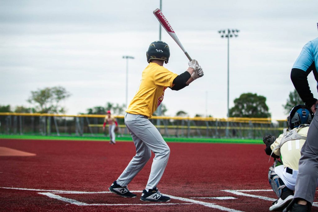 Youth baseball player preparing to swing at pitch.